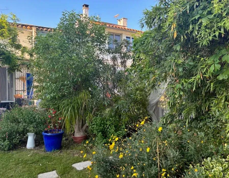 Extérieur du gîte avec beaucoup de verdure, ombragé et mobilier de jardin